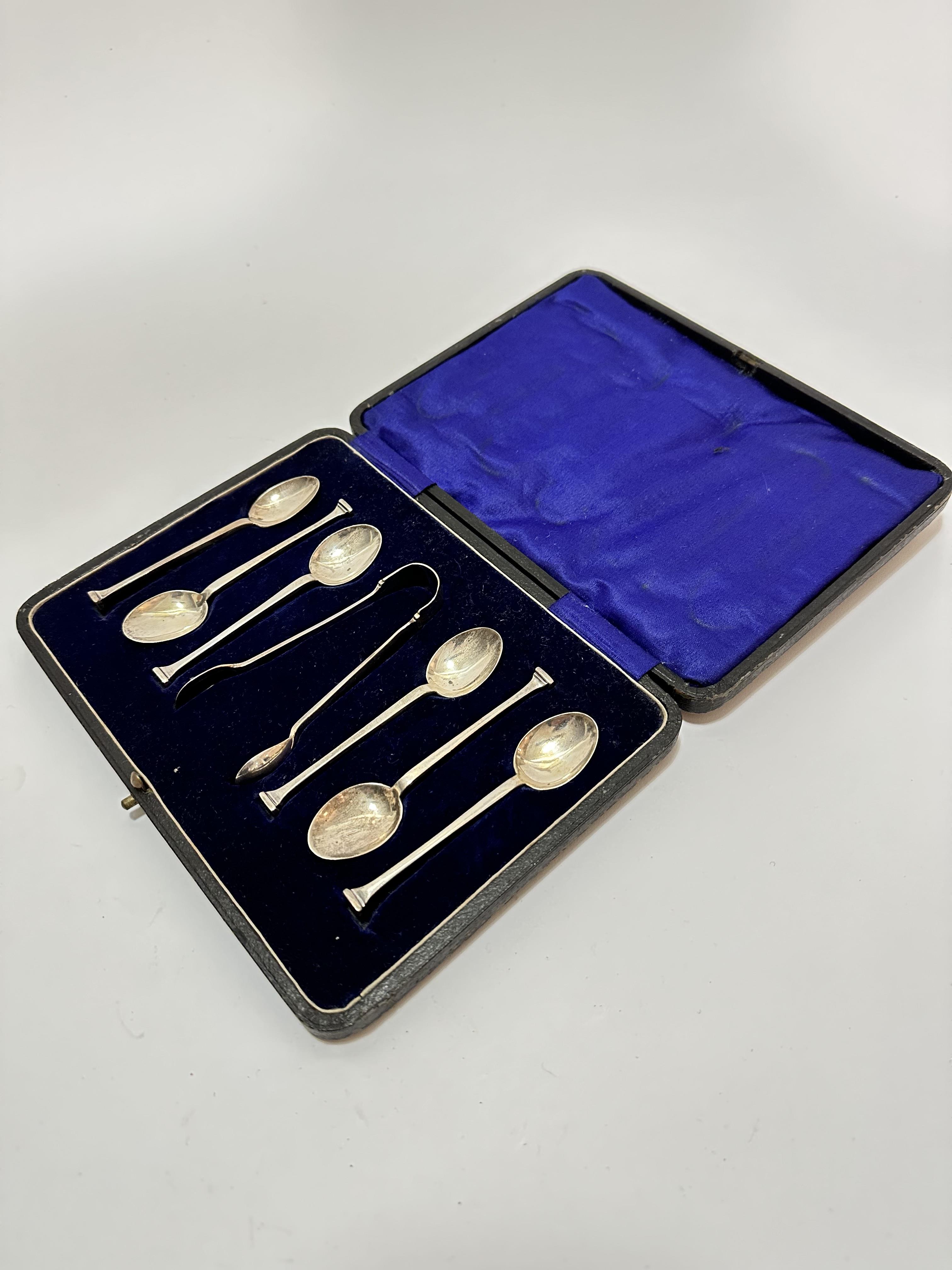 A set of six Sheffield silver seal handled coffee spoons complete with tongs, in original fitted