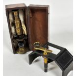 A mahogany case containing an Edwardian brass portable microscope with adjustable lens and a cast