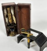 A mahogany case containing an Edwardian brass portable microscope with adjustable lens and a cast