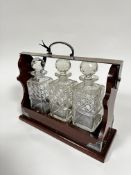 A mahogany Epns mounted tantalus complete with set of three crystal slice cut square whisky