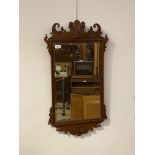 A Georgian style mahogany fret cut wall mirror carved with Prince of Wales feathers over bevelled