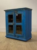 A rustic reclaimed timber glazed two door table cabinet finished in distressed blue paint, H70cm,