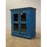 A rustic reclaimed timber glazed two door table cabinet finished in distressed blue paint, H70cm,