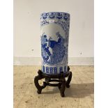 A modern Chinese style blue and white ceramic cylindrical stick stand, on carved hardwood base,