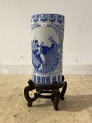 A modern Chinese style blue and white ceramic cylindrical stick stand, on carved hardwood base,