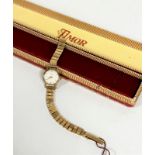 A lady's Timor 9ct gold wrist watch on 9ct gold adjustable flexible bracelet with champagne dial and