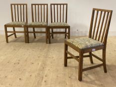 A Set of four George VI dry oak country dining chairs with spar backs, drop in seat pads, raised