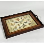 An Edwardian mahogany inlaid two handled tea tray with inset sewn work panel with butterflies and