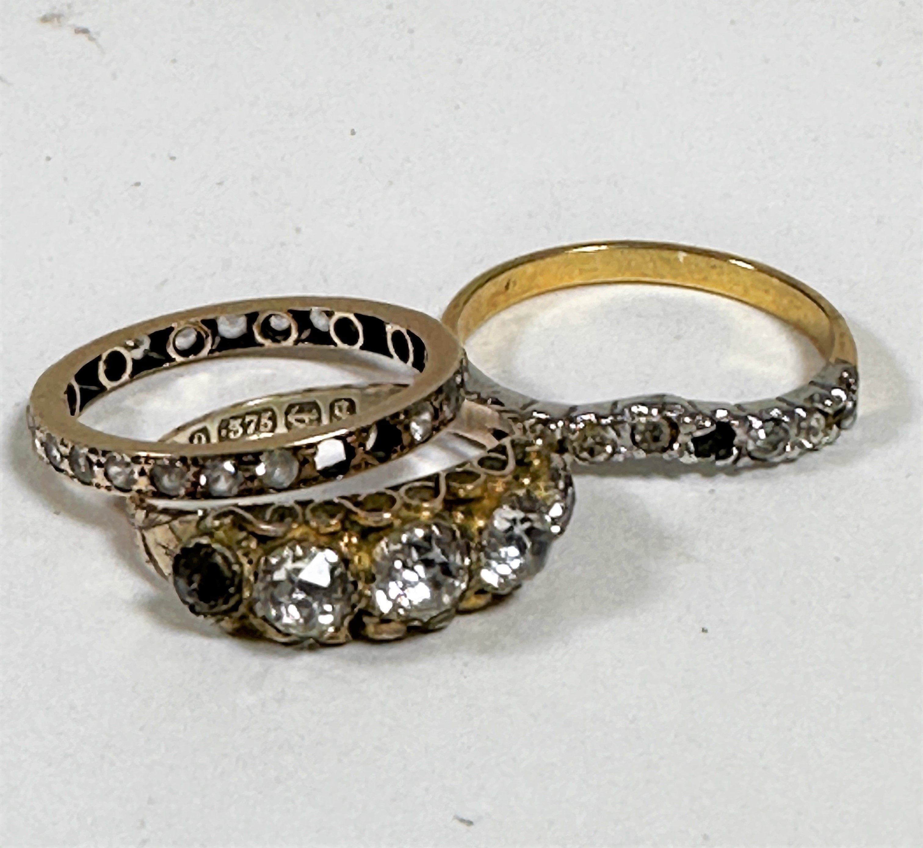 A 9ct gold paste set five stone graduated ring, a yellow metal clear stone set eternity style ring