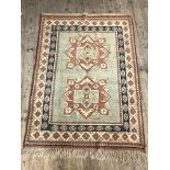 A hand knotted Turkish rug, sage green field with double medallion and geometric motif to border