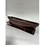 A 19thc mahogany model of a sailing vessel in the 18thc style, missing masts, complete with hardwood