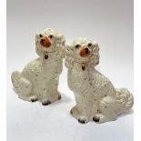 A pair of 19thc Staffordshire chimney spaniels decorated with polychrome enamels and gilt collars