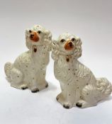 A pair of 19thc Staffordshire chimney spaniels decorated with polychrome enamels and gilt collars