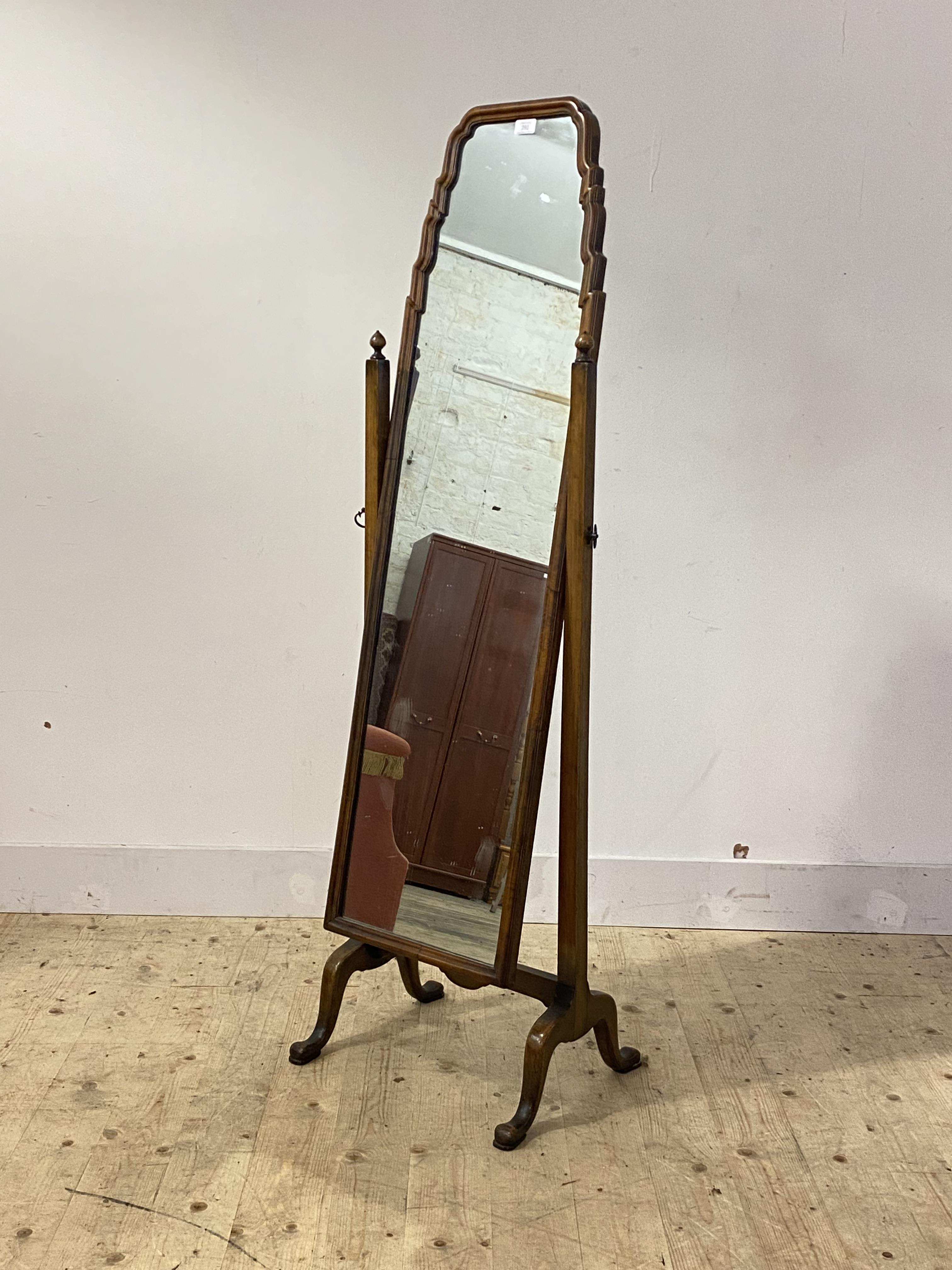 A 1920's walnut framed cheval mirror of 18th century design, the full length mirror with arched