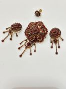 A late 19th early 20thc garnet cluster brooch with centre cluster and swags with drops, some