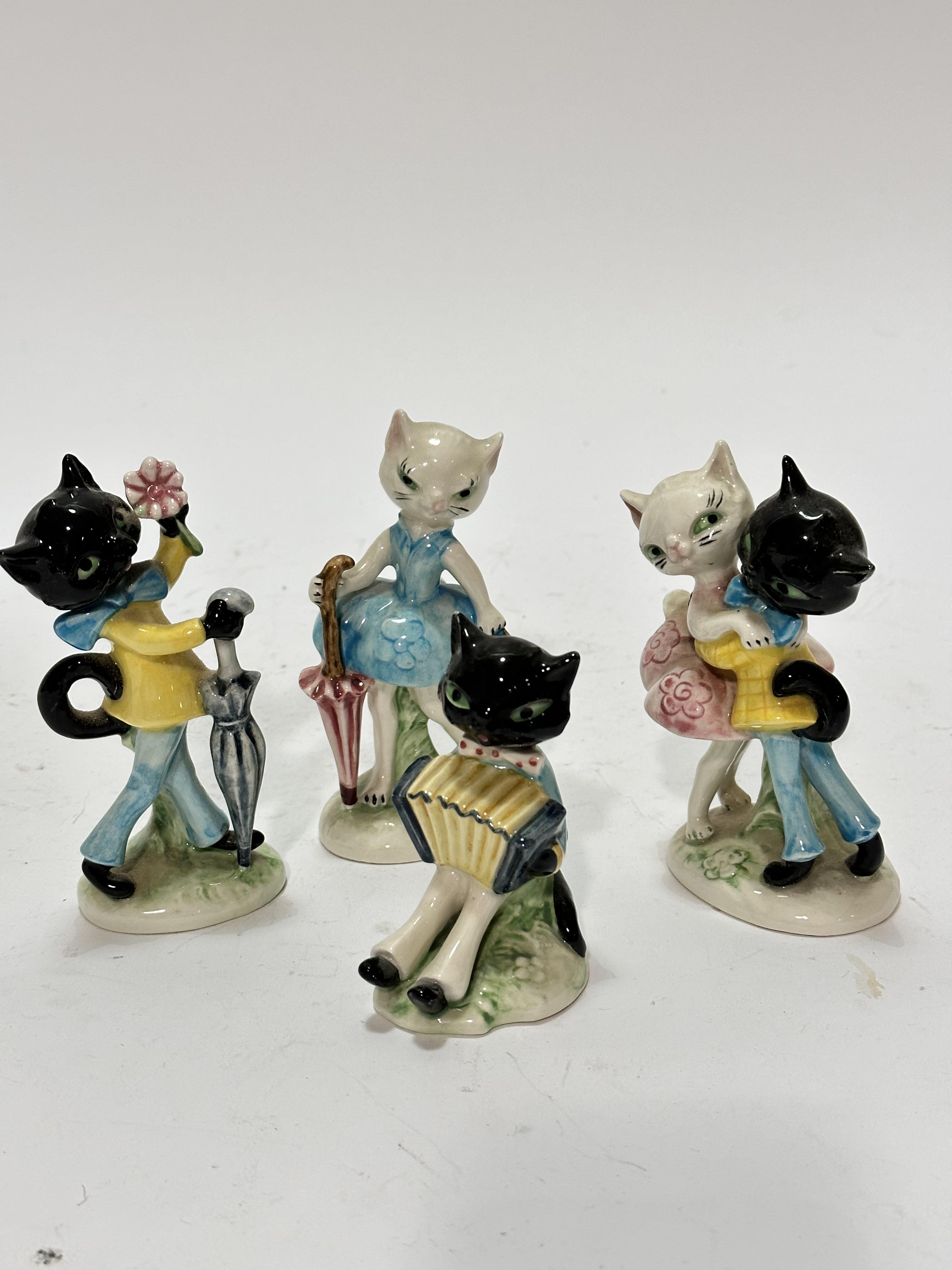 A Hummel collection of four various novelty cat figures including a courting couple, a female cat