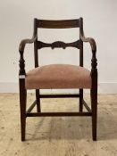 A George III mahogany elbow chair, the carved rail back over down swept arms with turned