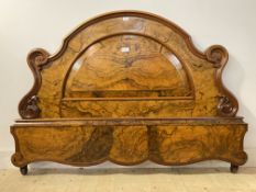 A Victorian figured walnut headboard, the arched and scrolling frame enclosing a fielded panel to