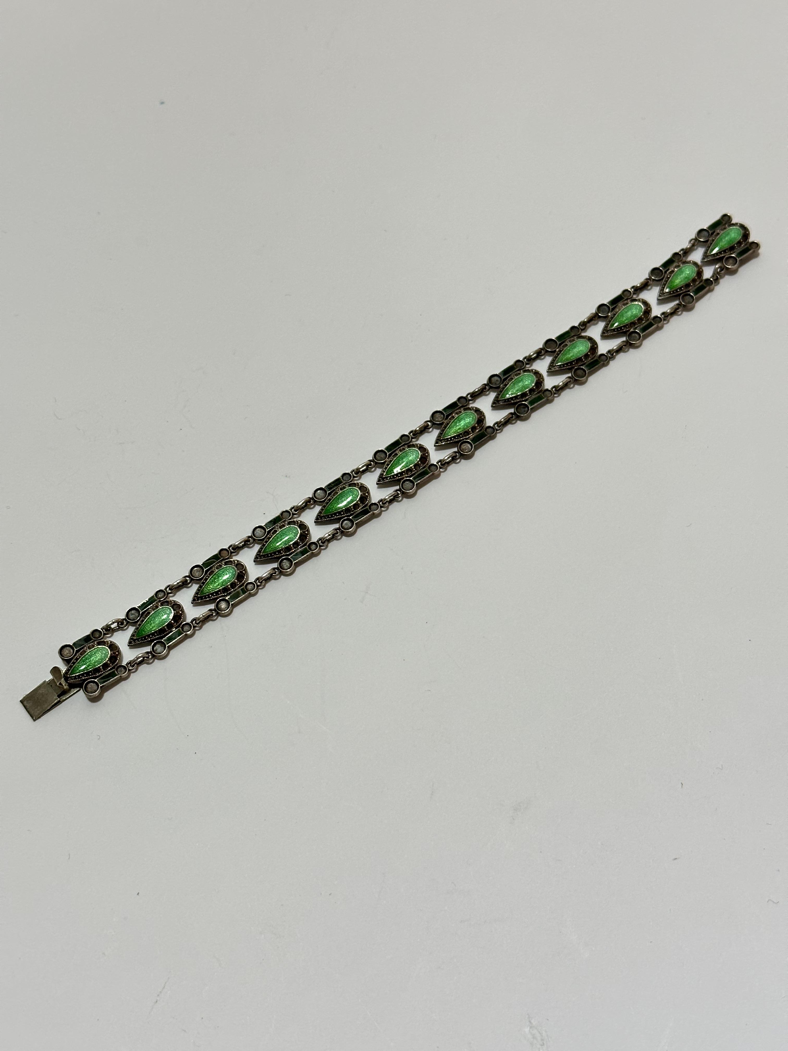 A silver Norwegian style navette shaped enamelled articulated bracelet with enamelled panels to side
