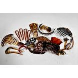 A collection of vintage faux tortoiseshell hair combs and amber hair pins, some with jeweled