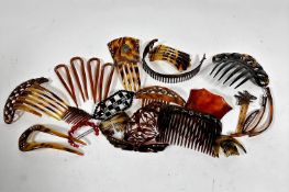 A collection of vintage faux tortoiseshell hair combs and amber hair pins, some with jeweled