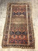 An Antique Caucasian rug, red ground within guarded border having flower head motif, 131cm x 240cm