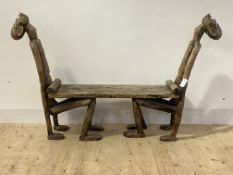 An unusual African stinkwood hall bench formed as two crouching figures supporting a plank seat