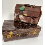 A stamped crocodile skin travelling case with satin lined interior a/f and brass locks, with gilt