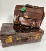 A stamped crocodile skin travelling case with satin lined interior a/f and brass locks, with gilt
