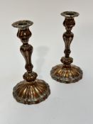 A pair of 19thc Sheffield plated baluster fluted stemmed candlesticks complete with drip trays to