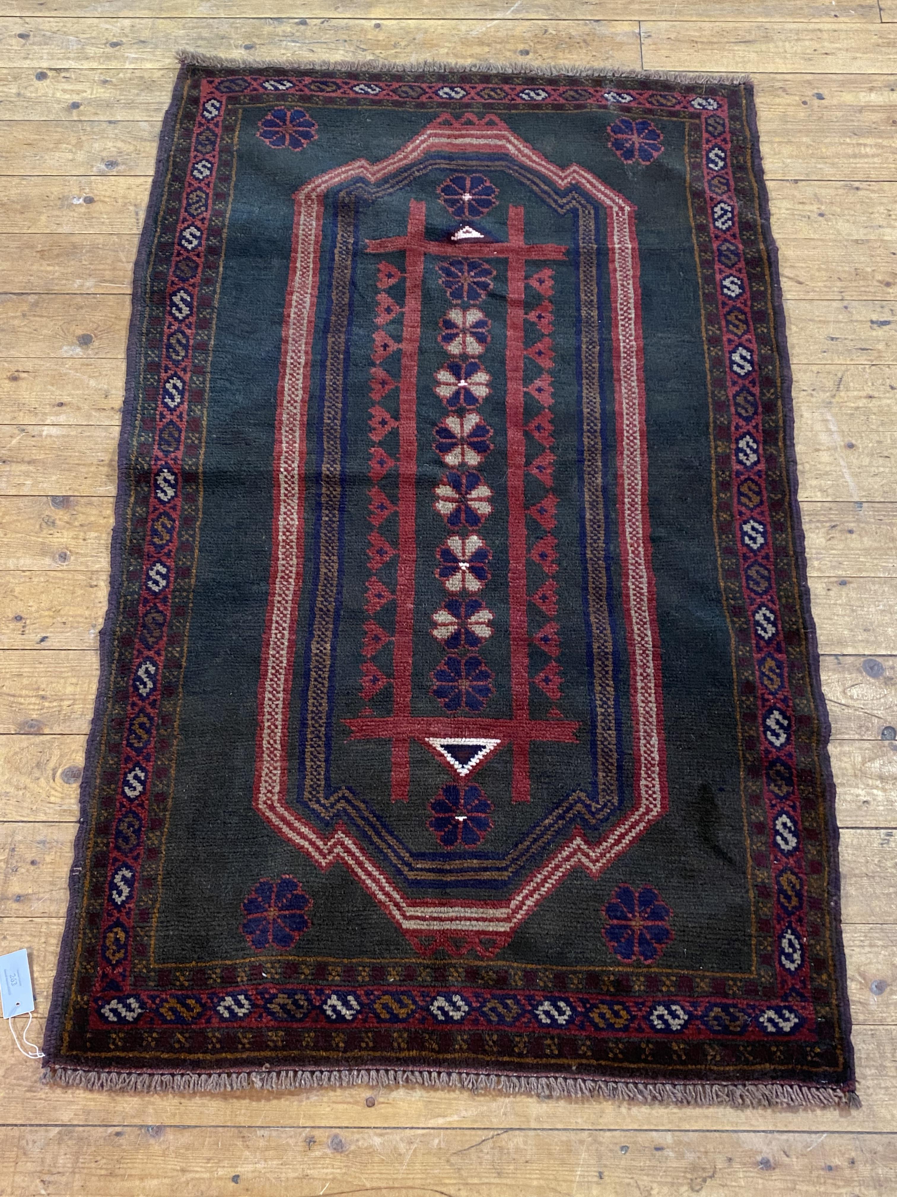 A hand knotted new baluchi rug, the black field with stylised floral design, guarded border 155cm