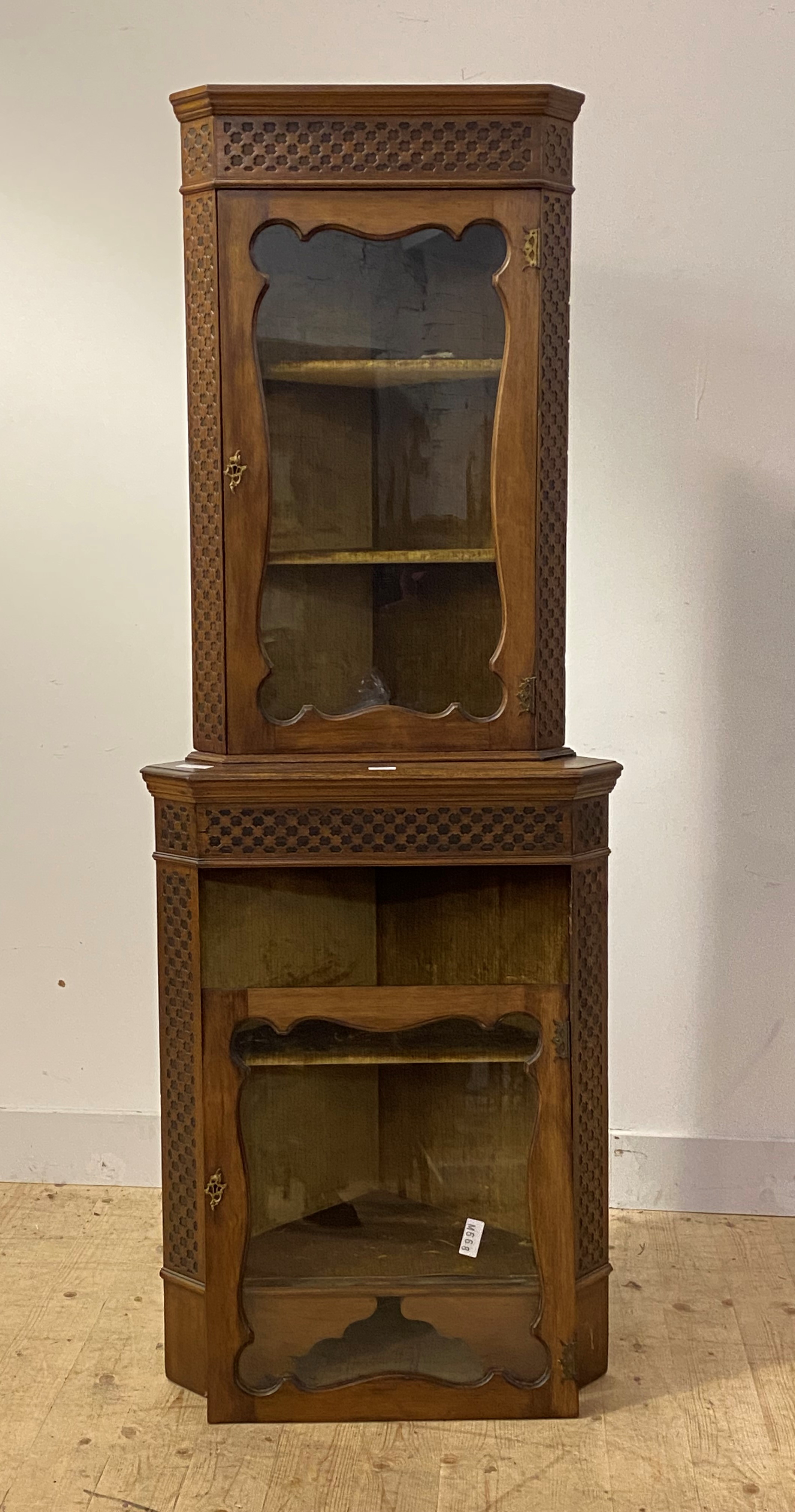 An Early 20th century two part floor standing corner cabinet, two glazed doors framed within blind