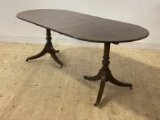 A Regency style mahogany twin pillar dining table, with leaf, moving on castors, H74cm, W91cm,