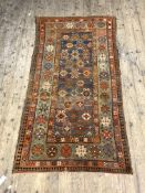 An Antique Caucasian rug, hand knotted, the blue field with geometric motif within a green border