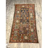An Antique Caucasian rug, hand knotted, the blue field with geometric motif within a green border