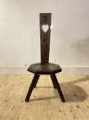 An early 20th century carved oak spinning chair, on three splayed supports H89cm