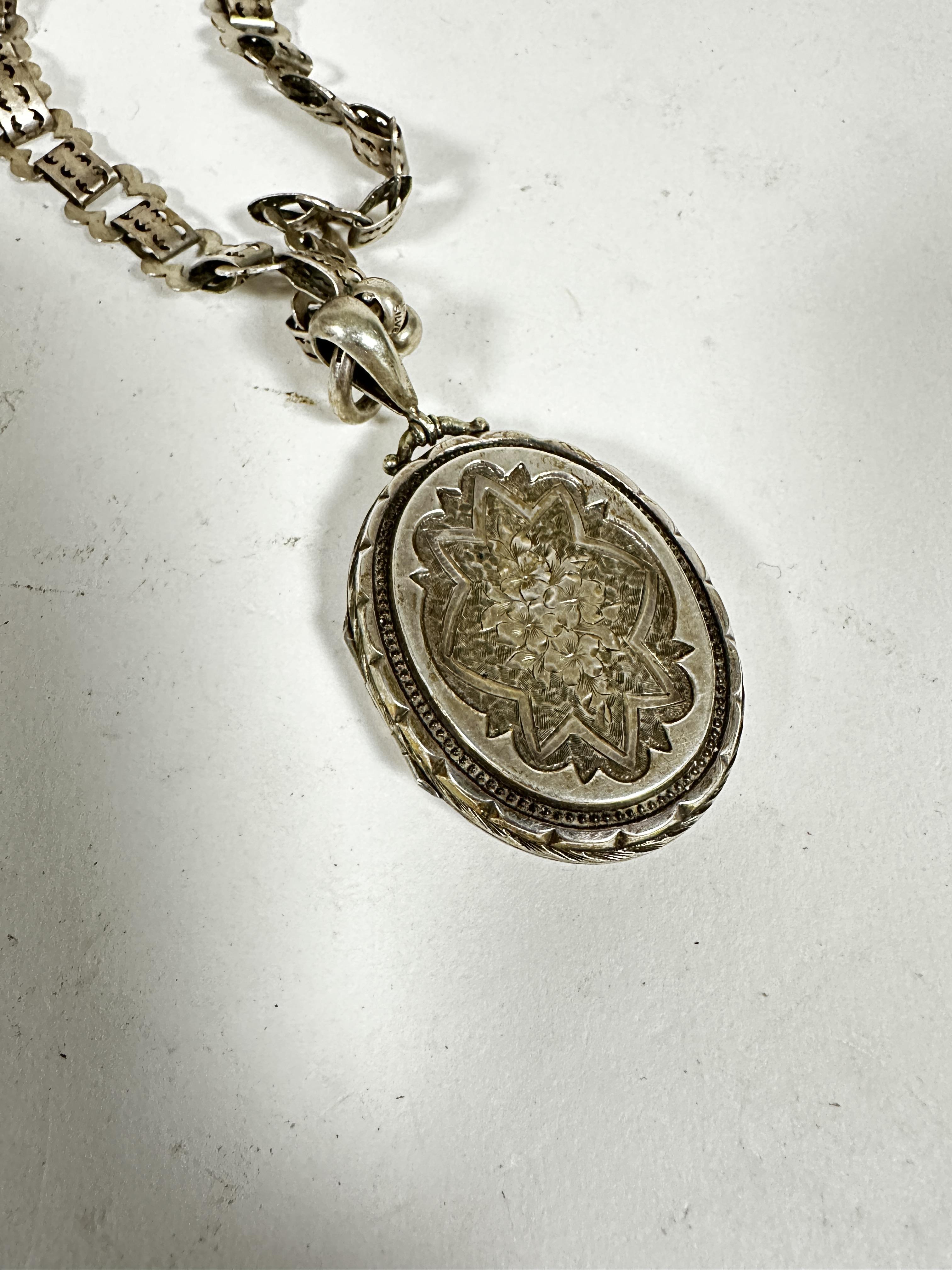 A Victorian oval white metal locket with engraved decoration and gadroon border mounted on white - Image 3 of 3