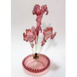 An Edwardian pale pink cranberry glass four branch epergne, the centre of iris style design with