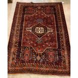 A Persian hand knotted Shiraz wool pile rug, red ground with geometric design and multi line