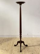 A Georgian style mahogany torchere, early 20th century, the circular top over reeded and turned