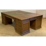 A monumental 19th century oak quadruple pedestal partners desk, the top inset with tooled green