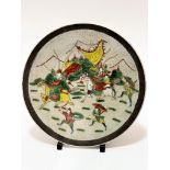 A Japanese craquelure ware charger decorated with Samurai figures on horseback and attendant