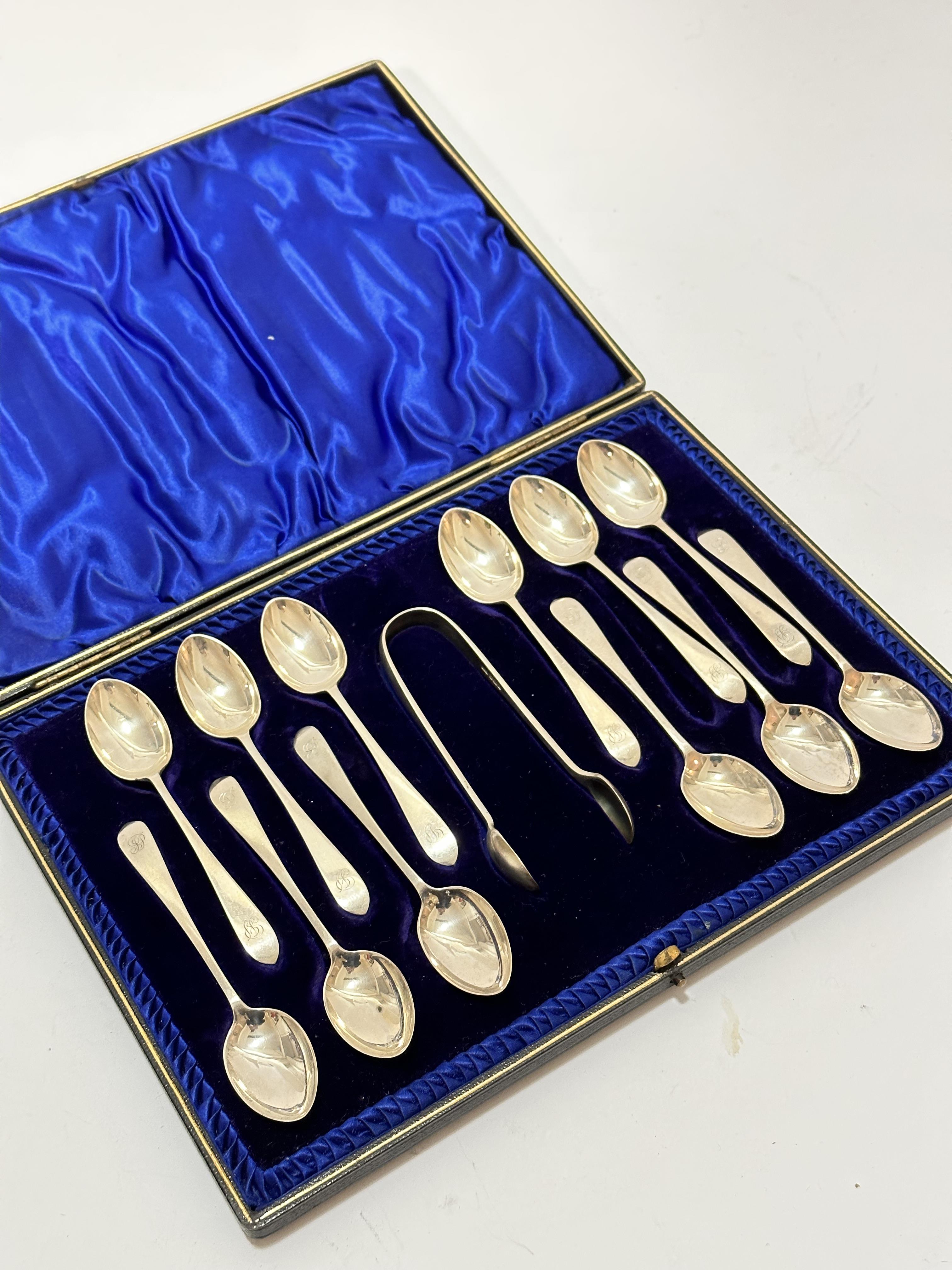 A set of twelve Sheffield silver old English pattern teaspoons complete with tongs with engraved