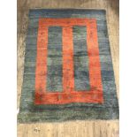 A Persian style Gabbeh rug, hand knotted, the abrashed blue ground with geometric red panel and