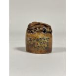 A Chinese soapstone seal, oval, carved in relief with a dragon, and bearing an inscription to one