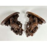 A pair of 19th century Black Forest carved wall brackets, each well modelled as an eagle, with