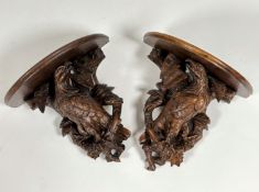 A pair of 19th century Black Forest carved wall brackets, each well modelled as an eagle, with