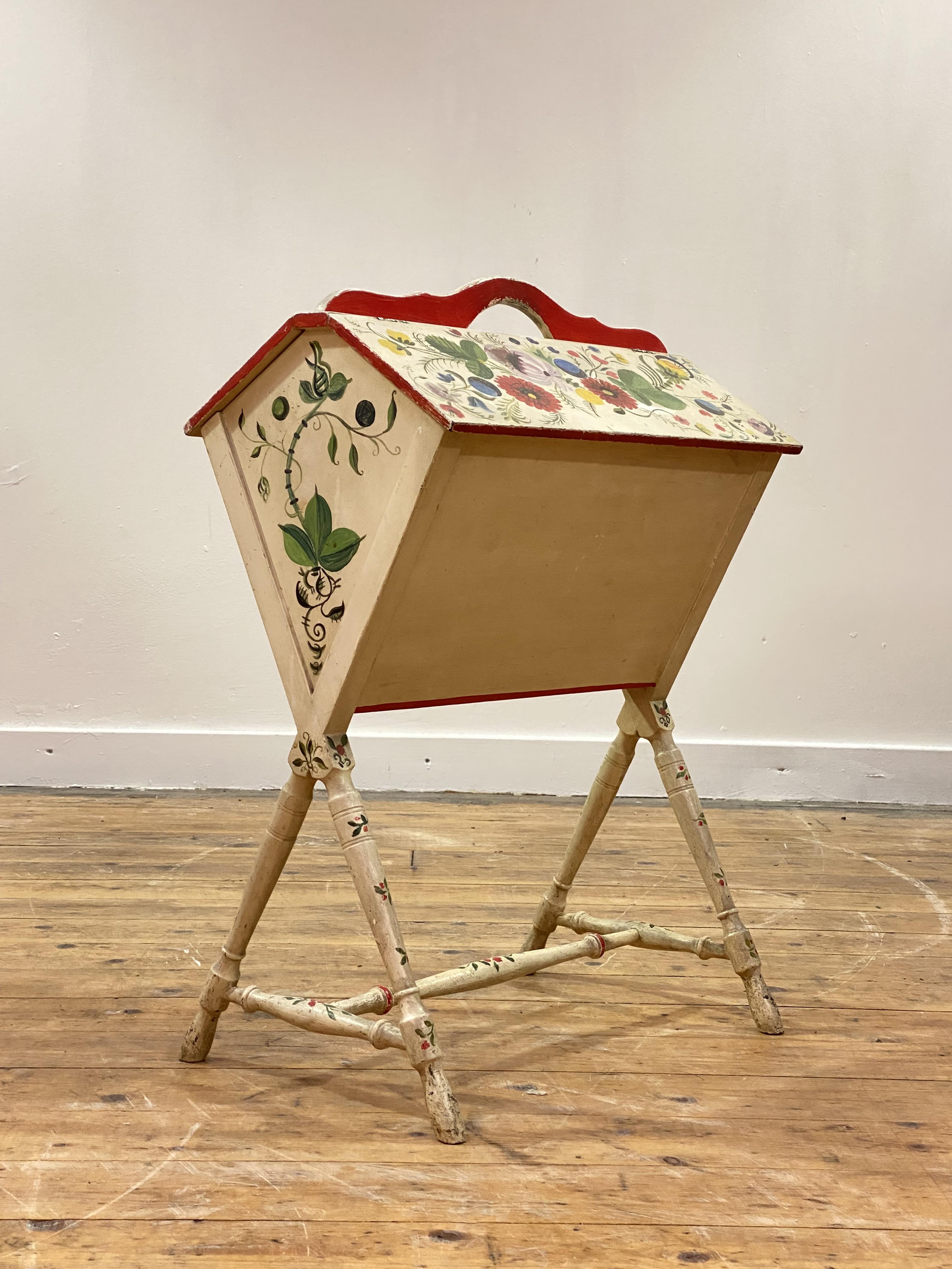 An early 20th century Scandinavian cream and floral painted music Canterbury, with pierced carry