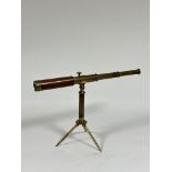 A late 19th/early 20th century brass two-draw telescope on folding brass tripod stand, engraved "