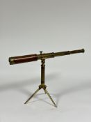 A late 19th/early 20th century brass two-draw telescope on folding brass tripod stand, engraved "